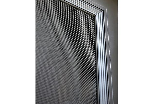 Corner detail of a security screen door showing the mesh held in the aluminium frame