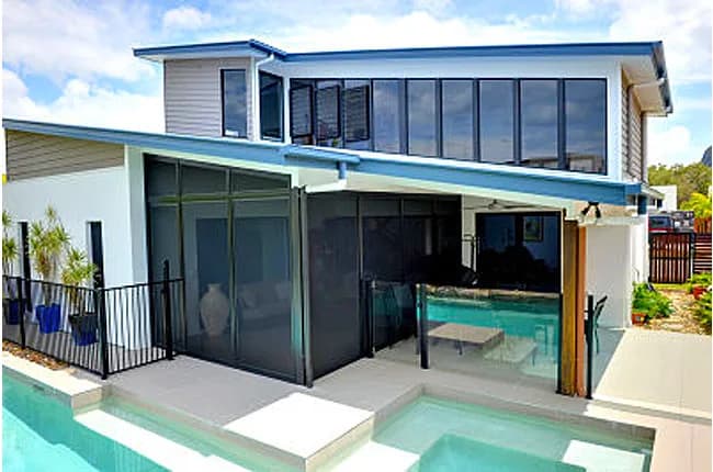Two storey modern home with security screens enclosing the poolside patio